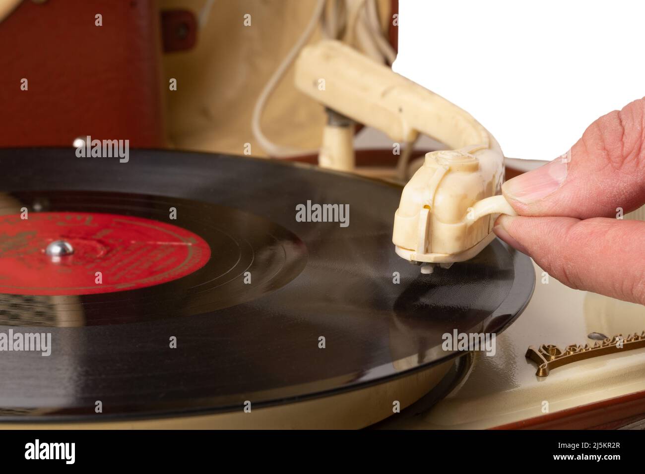 Die Hand eines Mannes senkt den Fuß des Tonabnehmers auf einer Schallplatte in einer Nahaufnahme eines alten Plattenspielers Stockfoto
