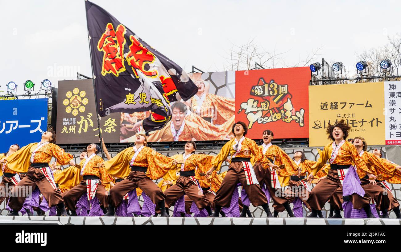 Japanisches Team von Yosakoi-Tänzern, die in Yukata-Tuniken tanzen und Naruko, Klatschen, auf der Freiluftbühne des Kyusyu Gassai Festivals in Kumamoto halten. Stockfoto