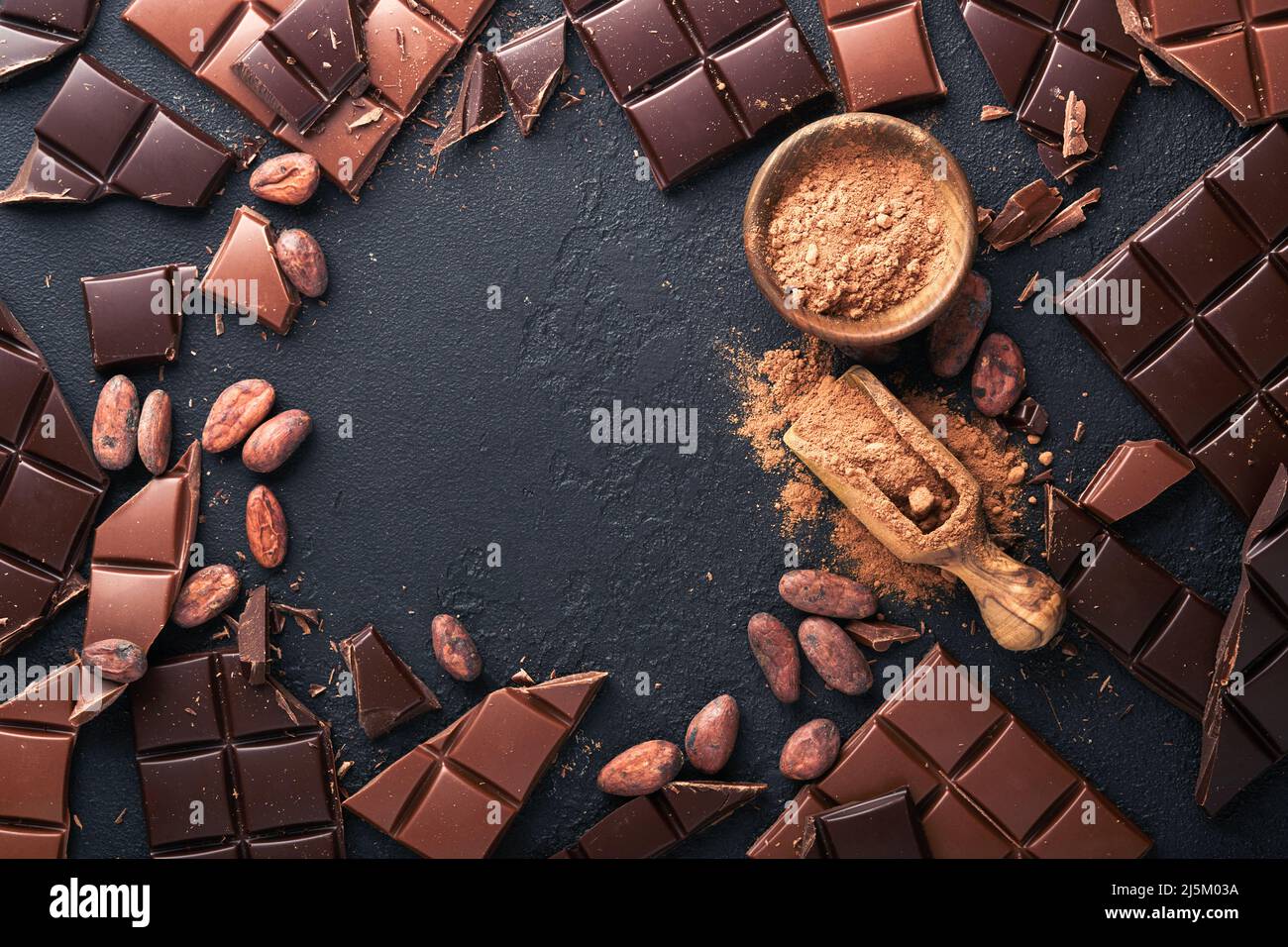 Schokolade . Zusammensetzung aus Kakaopulver, geriebenen und Bohnenkakaobars und Stücken verschiedener Milch und dunkler Schokolade auf schwarzem Hintergrund. Backschokol Stockfoto