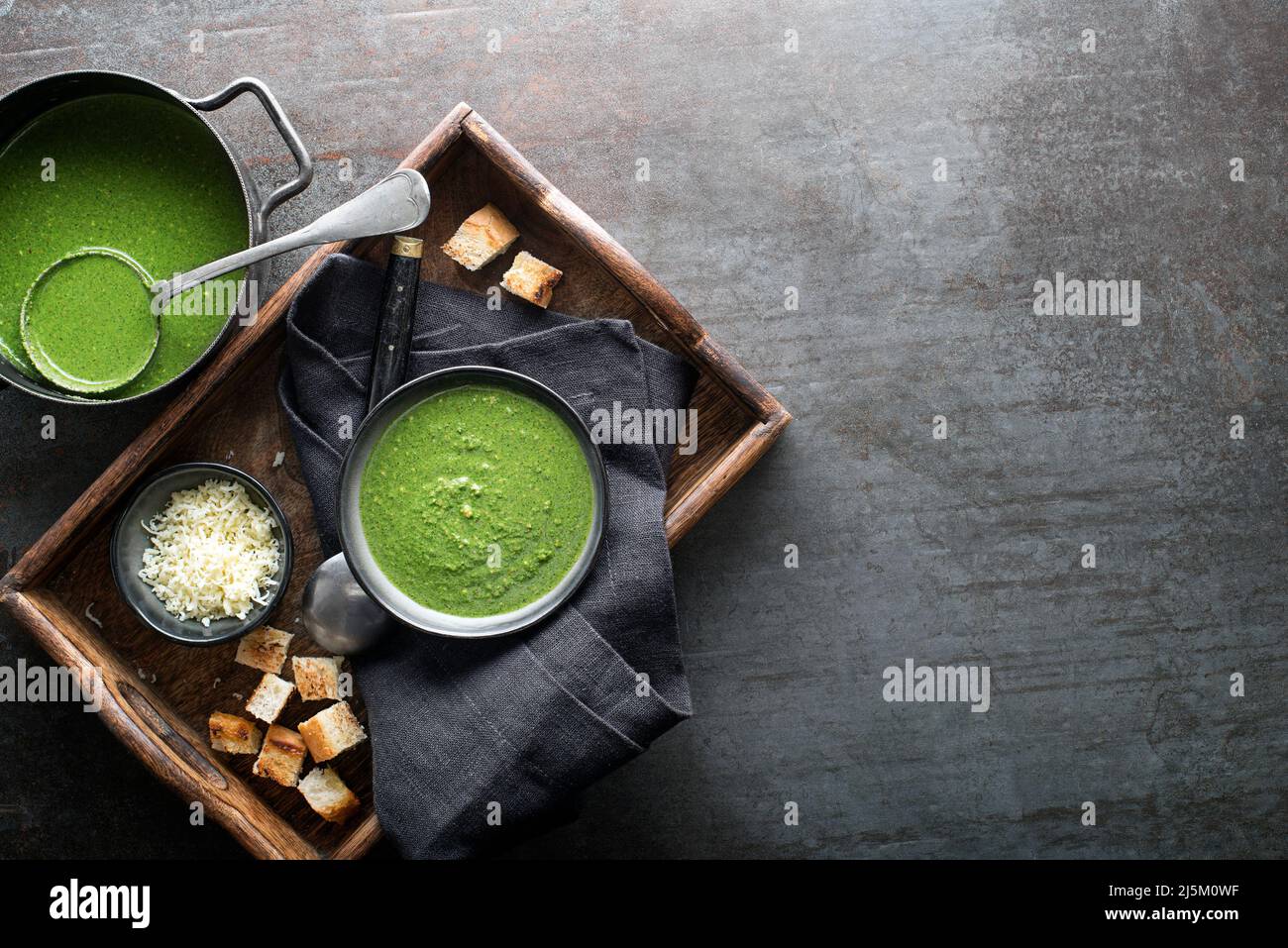Frische Gemüsesuppe mit Parmesankäse und Croutons auf grauem Hintergrund über dem Schuss. Stockfoto