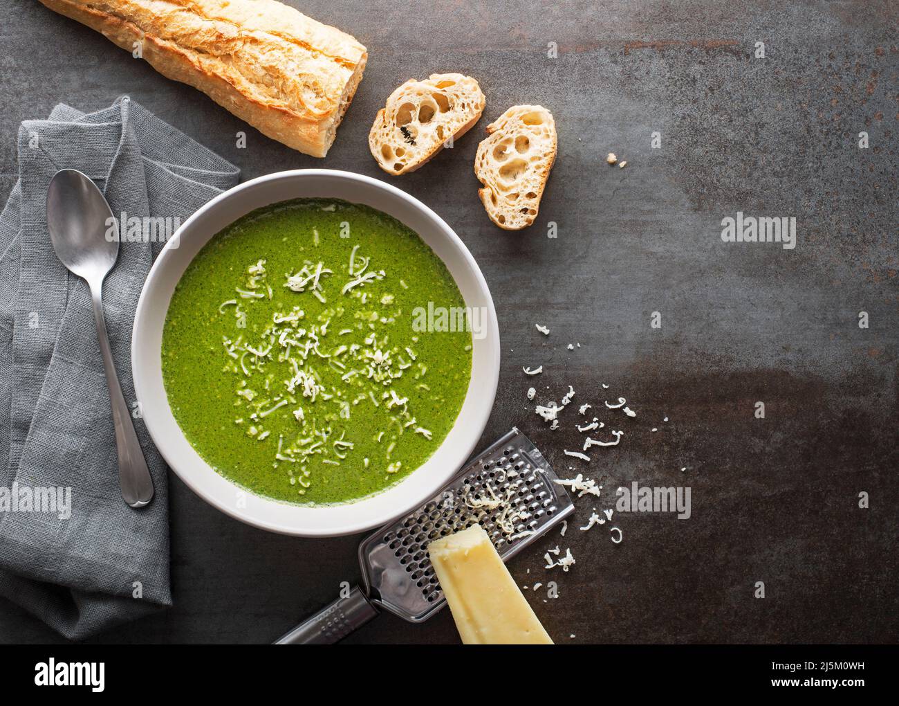 Frische Gemüsesuppe mit Parmesankäse auf grauem Hintergrund über dem Schuss. Stockfoto