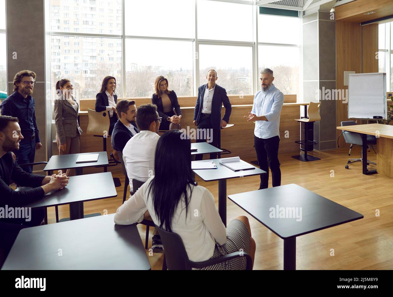 Team von Mitarbeitern, die sich im Büro treffen und einen Schulungskurs mit einem Business-Lehrer haben Stockfoto
