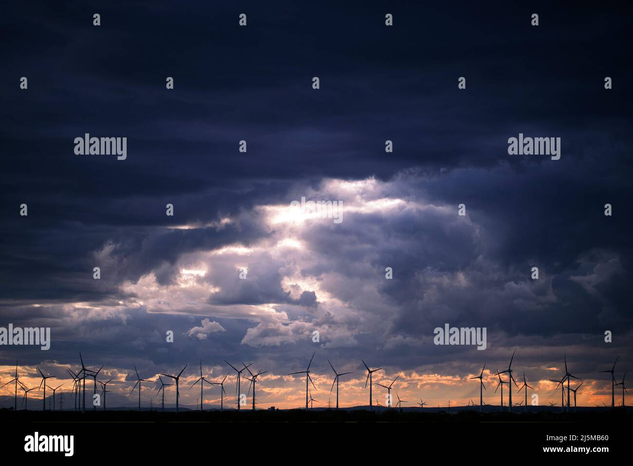 Dunkle Wolken Bei Sonnenuntergang Mit Windmühlen Im Hintergrund In Österreich Stockfoto
