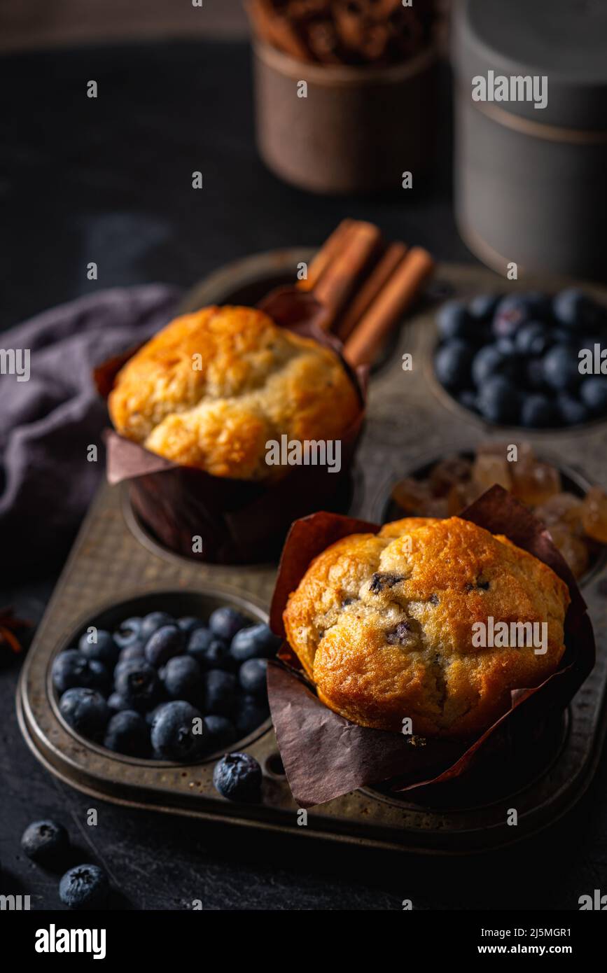 Süßes hausgemachtes Gebäck, Muffin mit Blaubeeren und frischen Beeren auf dunklem Hintergrund. Stockfoto
