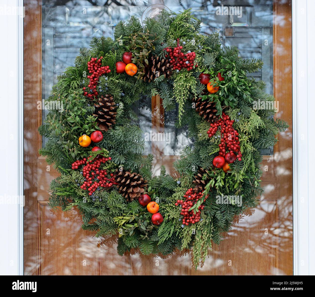 Nahaufnahme eines dekorativen Weihnachtskranzes an der Vordertür eines Hauses in Neuengland Stockfoto