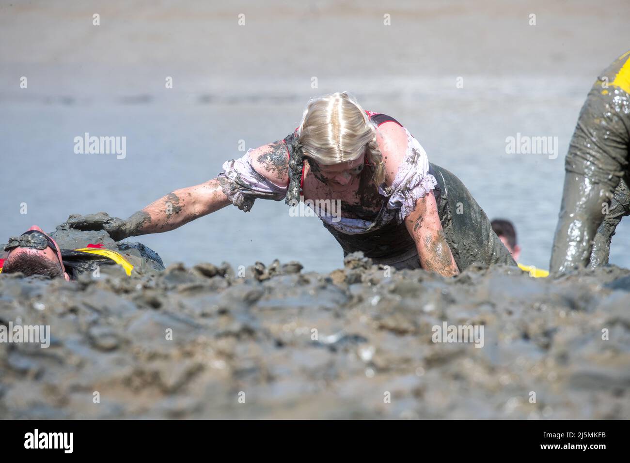 Ein Teilnehmer nimmt am Maldon Mud Race in Maldon, Essex, Teil, da das Rennen zum ersten Mal seit zwei Jahren zurückkehrt. Das Maldon Mud Race ist ein alljährliches Fun-Rennen, das im Frühjahr (ursprünglich im Winter, jetzt Ende April oder Anfang Mai) im Promenade Park in Maldon, Essex, England, stattfindet und bei dem die Teilnehmer um einen 500 Meter (550 Meter) langen Schuss in dickem Schlamm kämpfen. Über dem Bett des Flusses Blackwater. Das Rennen wird von den Lions & Rotary Clubs von Maldon und dem Maldon District Council organisiert, die Geld für wohltätige Zwecke sammeln. (Foto von Lucy North/SOPA Images/Sipa USA) Stockfoto