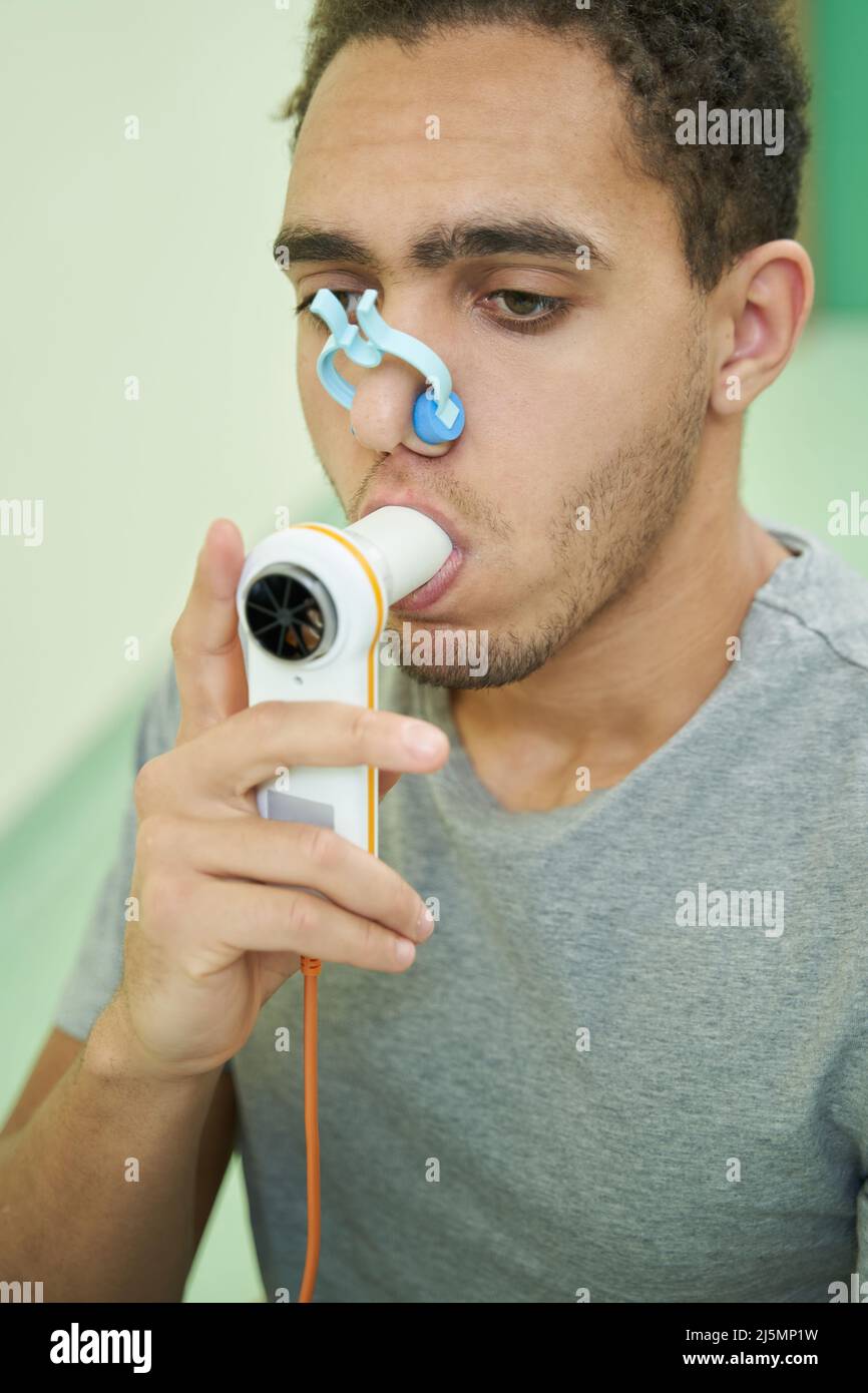 Person, die einen Lungenfinktionalitätstest mit einem Spirometriegerät durchgeführt hat Stockfoto