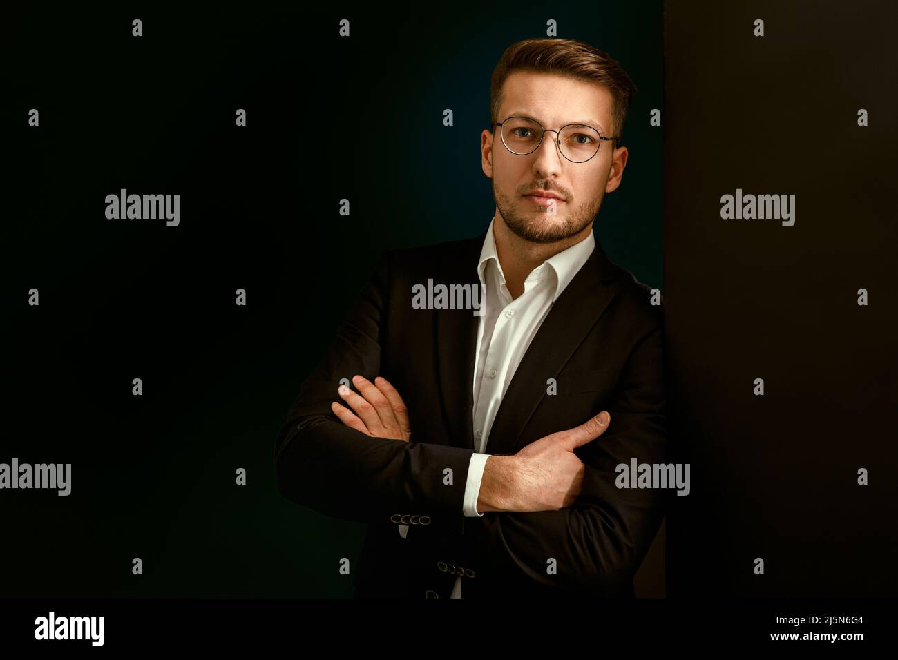 Porträt eines Geschäftsmannes in einem Anzug auf dunklem Hintergrund. Stockfoto
