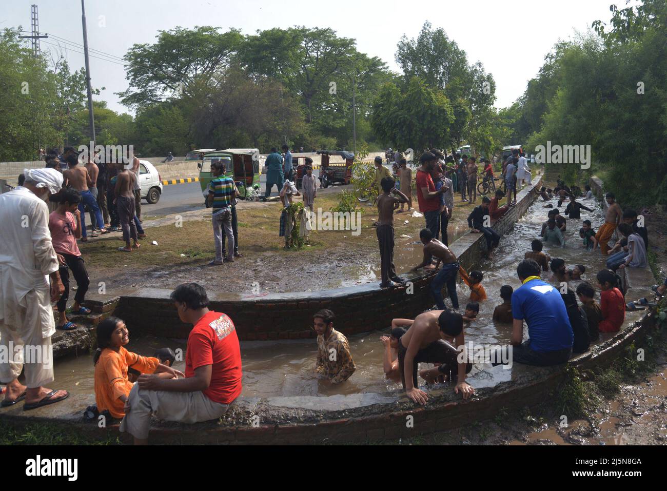 Lahore, Punjab, Pakistan. 24. April 2022. Pakistanische Jugendliche genießen ein Bad im Kanalwasser, um der Hitze zu entlasten und sich von dem warmen Wetter in Ramazan-ul-Mubarak in Lahore zu entlasten. (Bild: © Rana Sajid Hussain/Pacific Press via ZUMA Press Wire) Stockfoto
