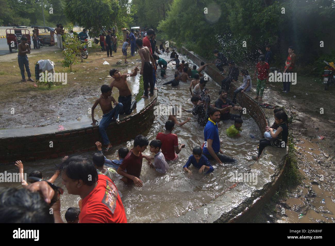 Lahore, Punjab, Pakistan. 24. April 2022. Pakistanische Jugendliche genießen ein Bad im Kanalwasser, um der Hitze zu entlasten und sich von dem warmen Wetter in Ramazan-ul-Mubarak in Lahore zu entlasten. (Bild: © Rana Sajid Hussain/Pacific Press via ZUMA Press Wire) Stockfoto