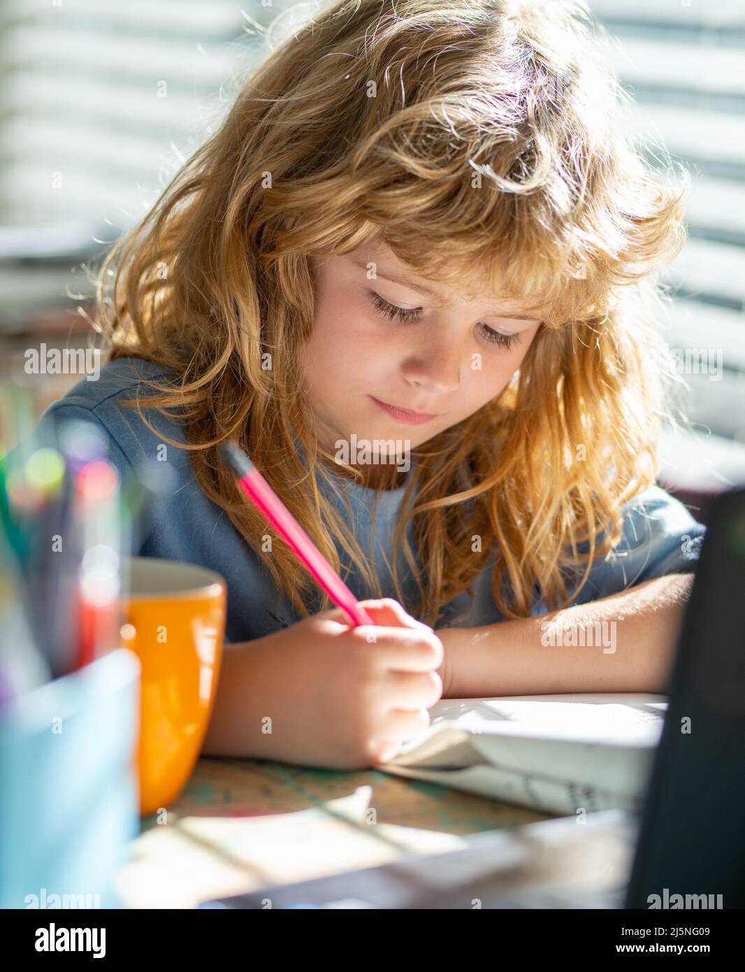 Kind schreibt Hausaufgaben in der Schulklasse. Kid boy zu Hause schreibt zeichnet, Klassen für ein Kind zu Hause. Homeschool Schuljunge macht Hausaufgaben und Lernen Stockfoto