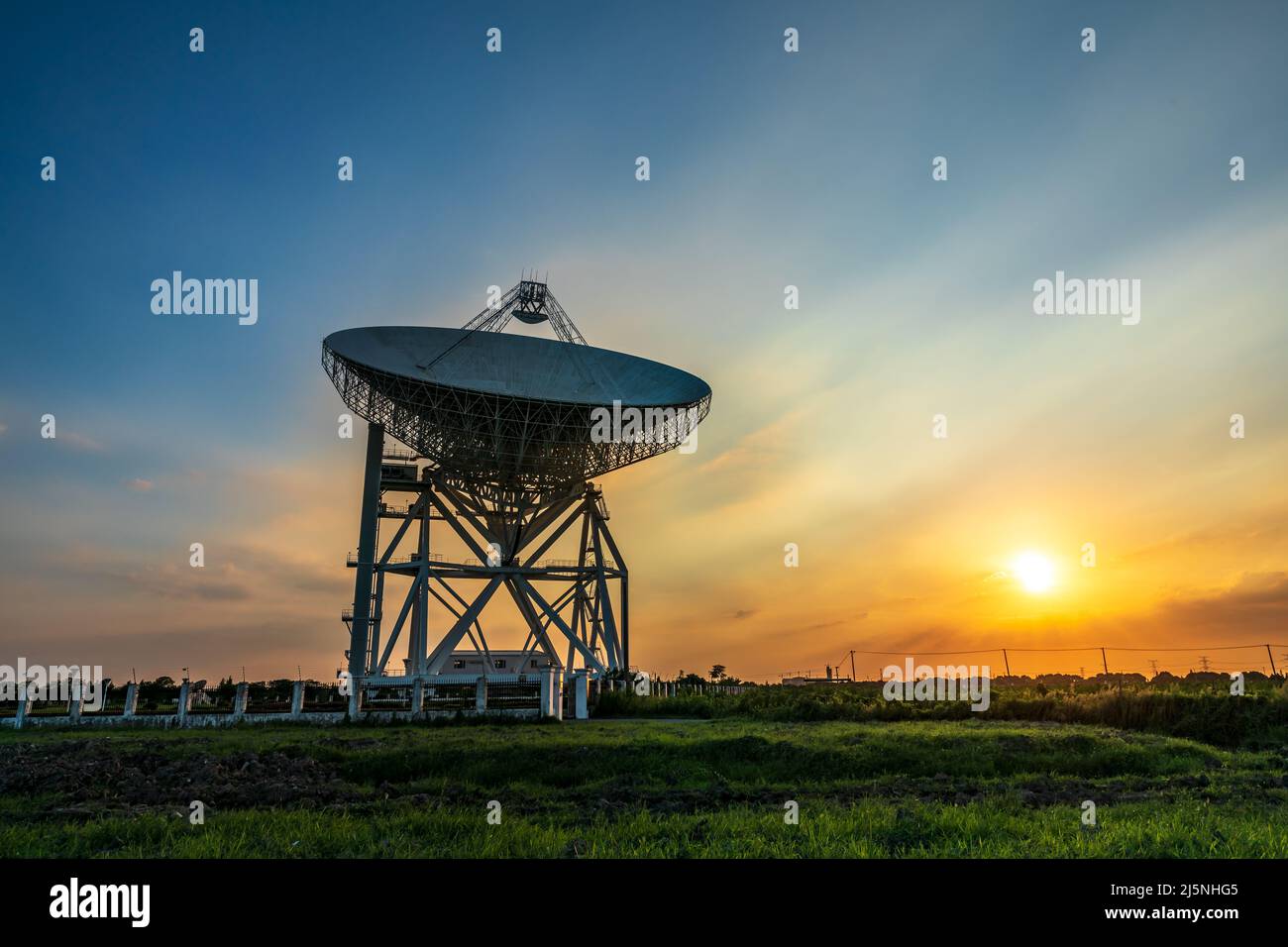 Astronomisches Radioteleskop und wunderschöne Himmelswolken bei Sonnenuntergang Stockfoto