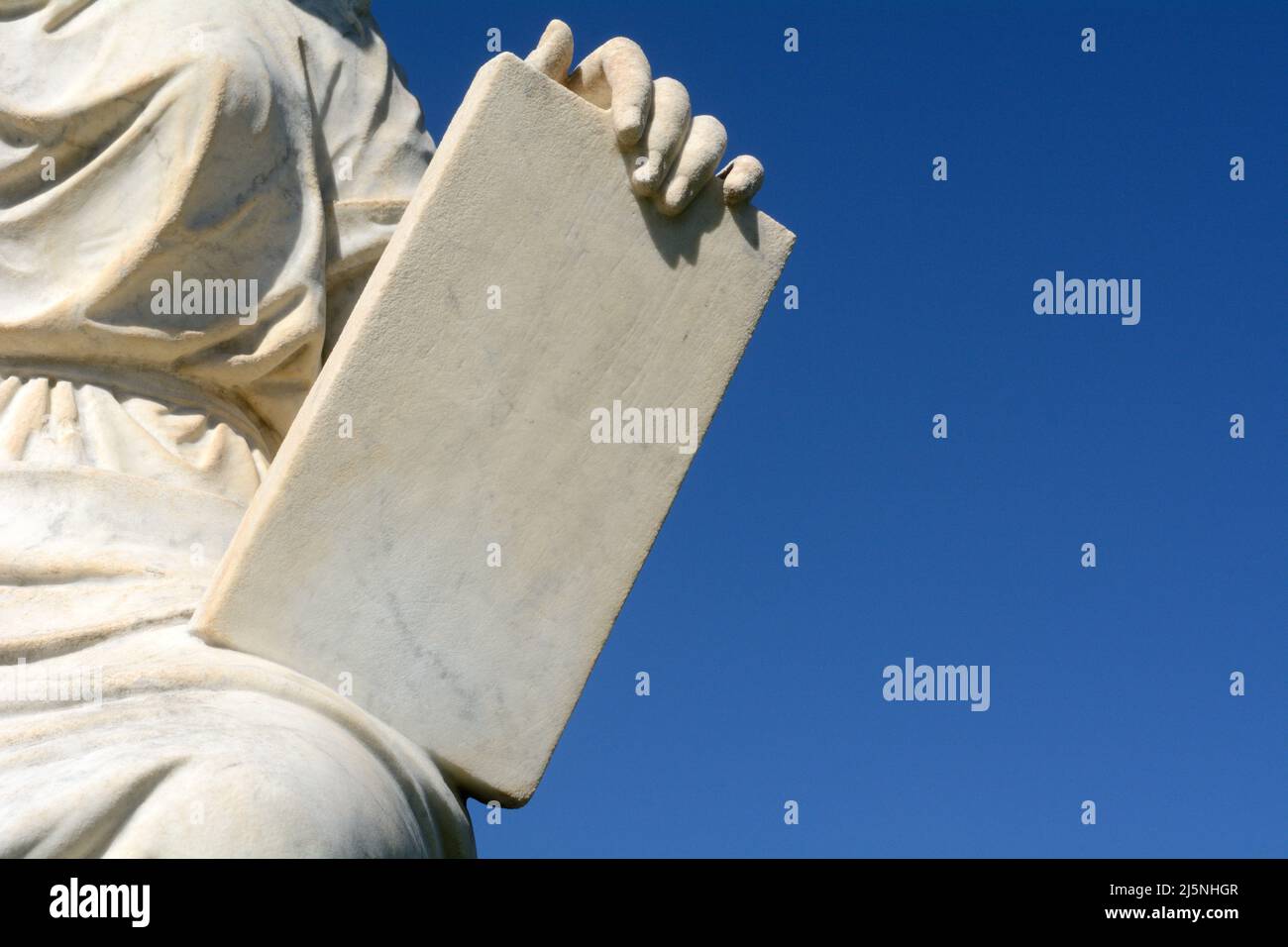 Hand hält Granitsteintafel am blauen Himmel Stockfoto