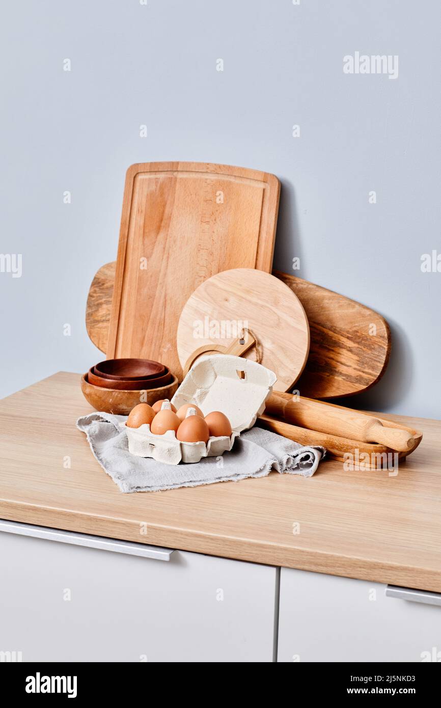 Bild von rohen Eiern mit Nudelholz und Brett, die sich für das Kochen des Teigs in der Küche vorbereiten Stockfoto