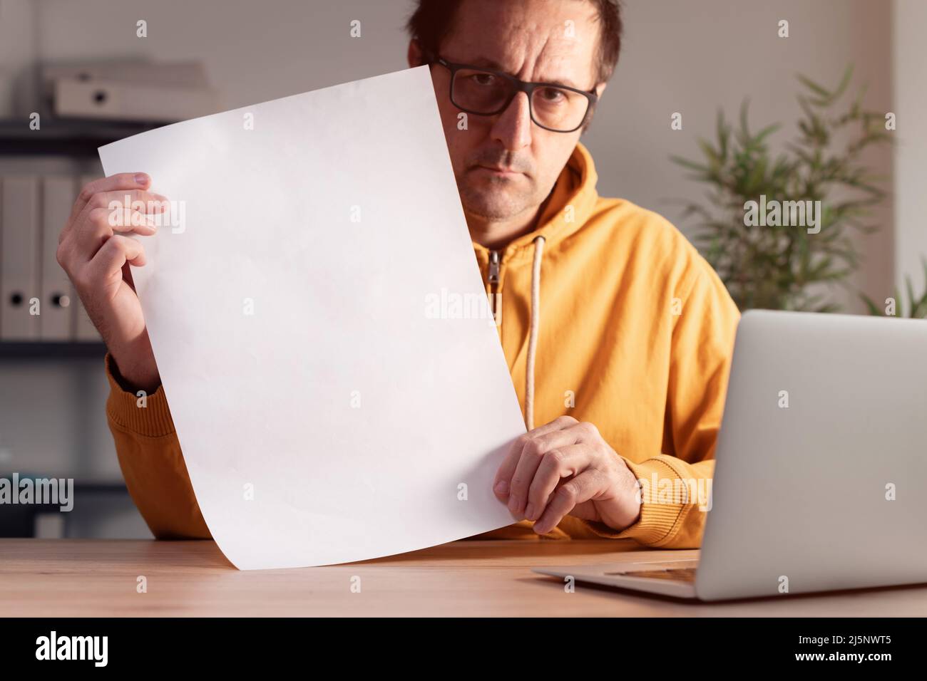 Freiberuflicher Mitarbeiter mit weißen, leeren Plakaten, Werbemockup im Heimbüro, selektiver Fokus Stockfoto