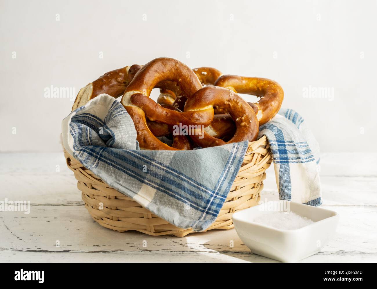 Brezeln oder Brezeln im Brotkorb mit Serviette und Salz Stockfoto
