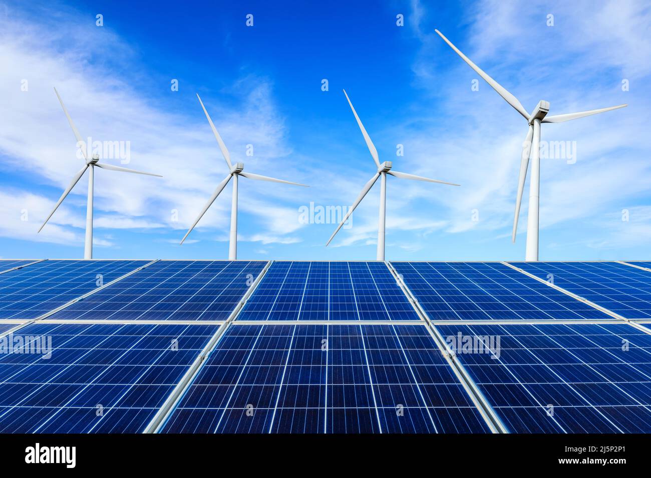 Sonnenkollektoren und Windkraftanlagen Landschaft unter blauem Himmel. Konzept für grüne Energie. Stockfoto