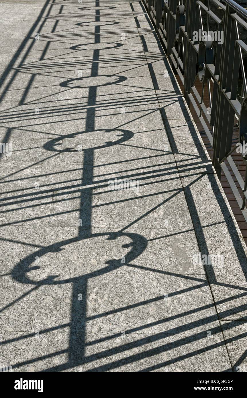 Verzierte Metallgeländer Silhouette auf dem Bürgersteig Stockfoto