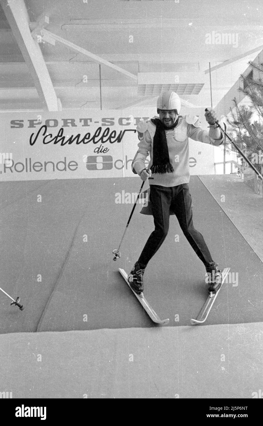 Walter Giller bei einer Werbeveranstaltung im Sporthaus Sport Scheck in München. Präsentiert wird die rollende Skipiste „schneller Otto“, auf der das Skifahren ausprobiert werden konnte. [Automatisierte Übersetzung] Stockfoto