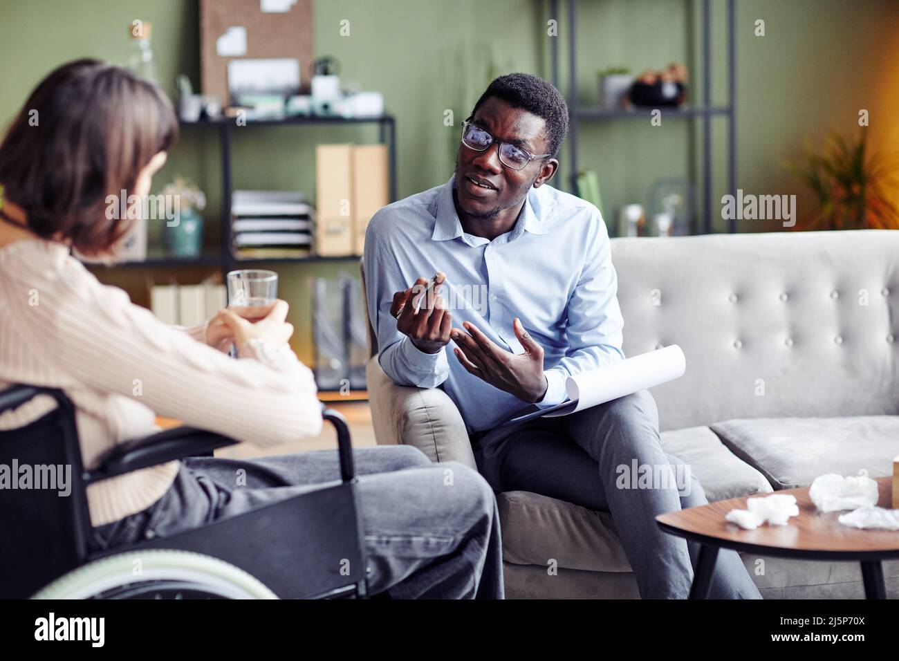 Psychologin, die junge Frau mit Behinderung, Stressmanagement und anderen Bewältigungsfähigkeiten unterrichtet Stockfoto