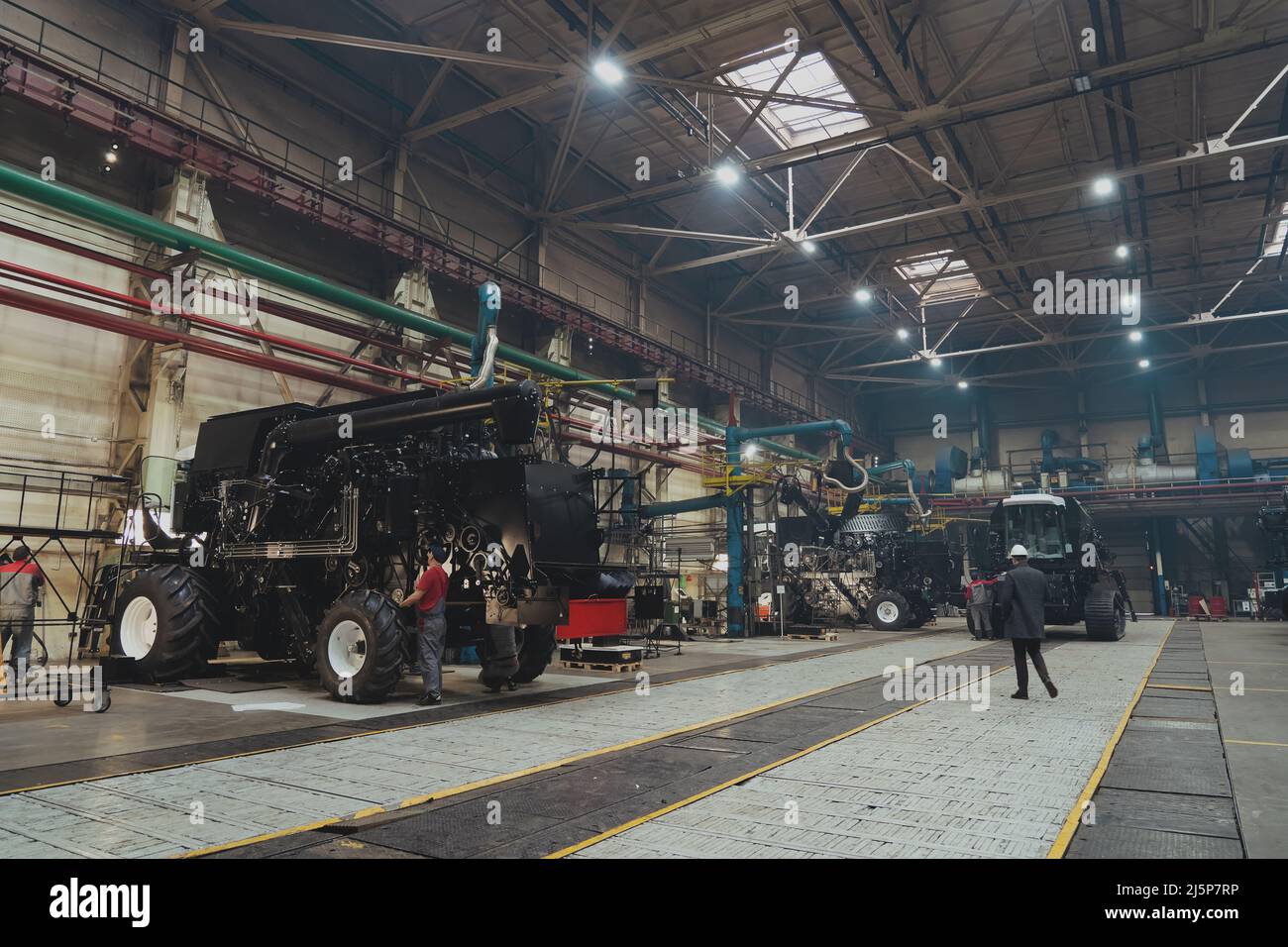 Große industrielle Werkstatt mit Traktoren, Mähdrescher in landwirtschaftlichen Maschinen Produktionsfabrik. Stockfoto