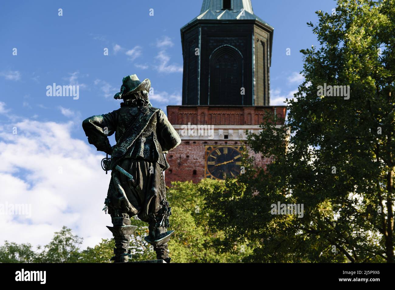 Die per Brahe Statue mit Blick auf den Turm der Turku Kathedrale, die mittelalterliche Basilika in Finnland gegen blauen Himmel im Sommer mit den Bäumen in der Stirn Stockfoto