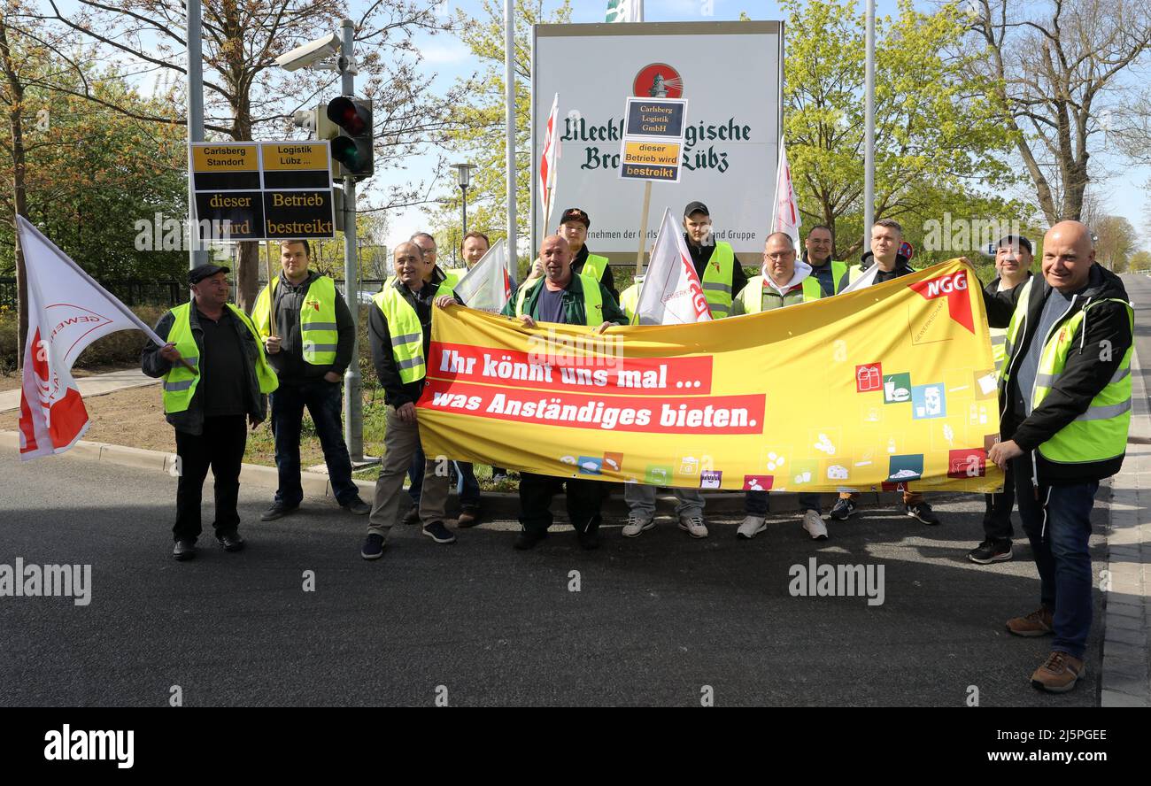 Mecklenburg-Vorpommern, Lübz: 25. April 2022, LKW-Fahrer, die am 24-stündigen Warnstreik teilnehmen, versammeln sich vor der Brauerei mit einem Transparent mit der Aufschrift: "Ihr könnt uns etwas anständiges anbieten." Die Aktion wurde von der Food and Catering Union Mecklenburg-Vorpommern (NGG) eingeleitet, die in der aktuellen Verhandlungsrunde mit der Muttergesellschaft Carlsberg (Hamburg) ein deutlich besseres Angebot fordert. Foto: Bernd Wüstneck/dpa Stockfoto