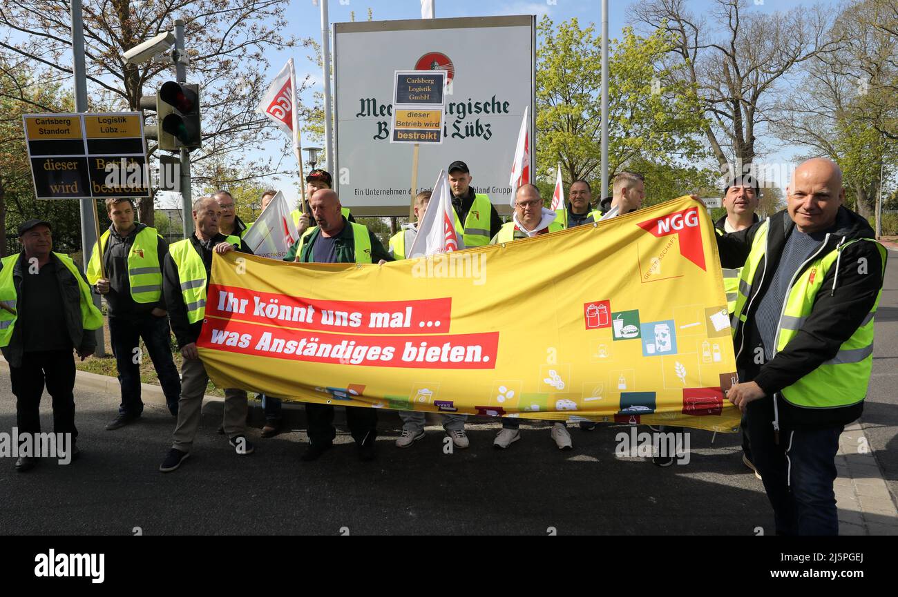 Mecklenburg-Vorpommern, Lübz: 25. April 2022, LKW-Fahrer, die am 24-stündigen Warnstreik teilnehmen, versammeln sich vor der Brauerei mit einem Transparent mit der Aufschrift: "Ihr könnt uns etwas anständiges anbieten." Die Aktion wurde von der Food and Catering Union Mecklenburg-Vorpommern (NGG) eingeleitet, die in der aktuellen Verhandlungsrunde mit der Muttergesellschaft Carlsberg (Hamburg) ein deutlich besseres Angebot fordert. Foto: Bernd Wüstneck/dpa Stockfoto