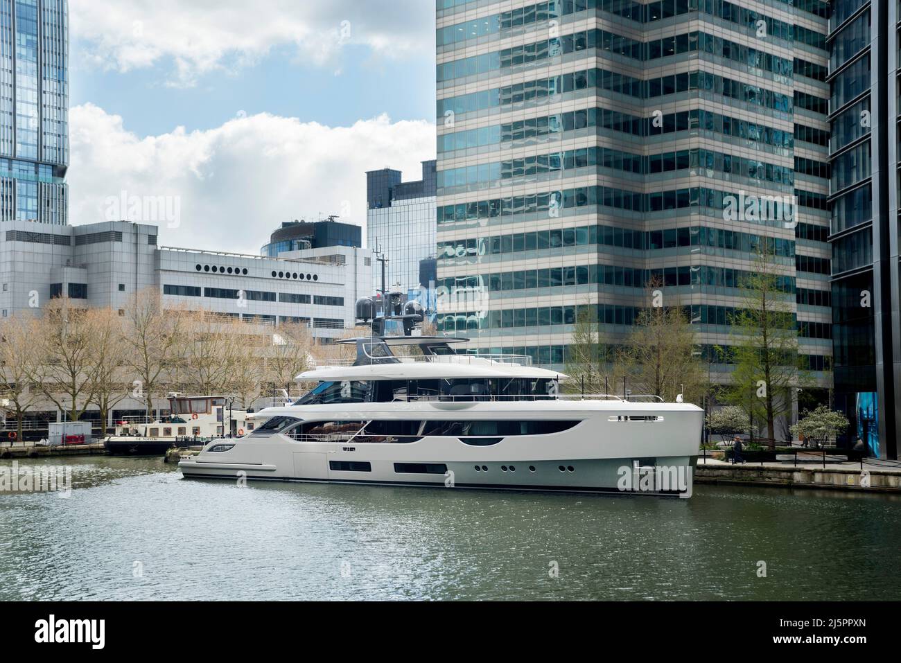 Weiße Superyacht vertäut in den Docks in Londons Canary Wharf. Ein super reicher Lebensstil. Stockfoto