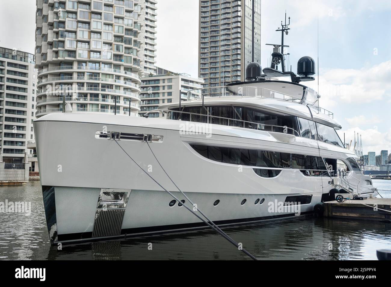 Weiße Superyacht vertäut in den Docks in Londons Canary Wharf. Ein super reicher Lebensstil. Stockfoto