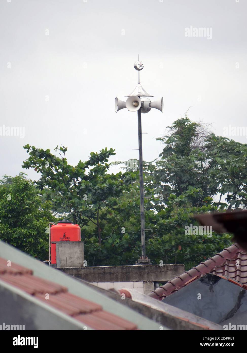 Ein Moschee-Lautsprecher auf einem Mast auf dem Dach ruft zum Gebet auf Stockfoto