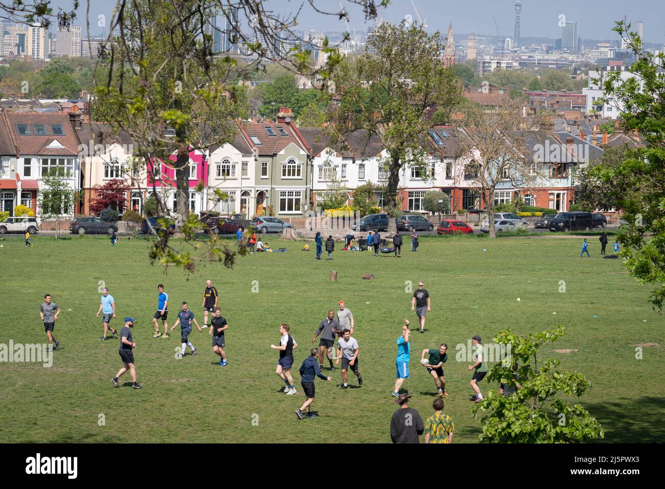 Am 24.. April 2022 wird im Ruskin Park, einer Grünfläche im Süden Londons mit Blick auf die Häuser in Lambeth, in London, England, ein lokales Spiel des Touch Rugby gespielt. Touch Rugby ist eine sicherere Variante des Rugby-Fußballs, bei der die Spieler sich nicht gegenseitig bekämpfen, sondern ihre Gegner mit ihren Händen an jedem Körperteil, an der Kleidung oder am Ball berühren. Stockfoto