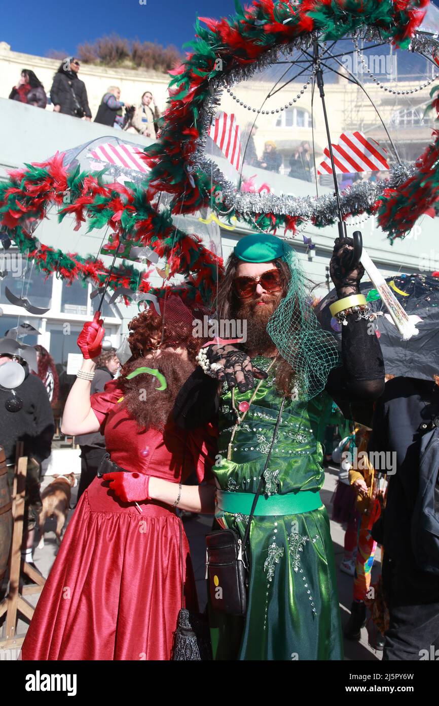 Bärtiger Mann in einem grünen Kleid bei der farbenfrohen Umbrella Parade, bei den Feierlichkeiten zum Fat Tuesday in Hastings, East Sussex, Großbritannien Stockfoto