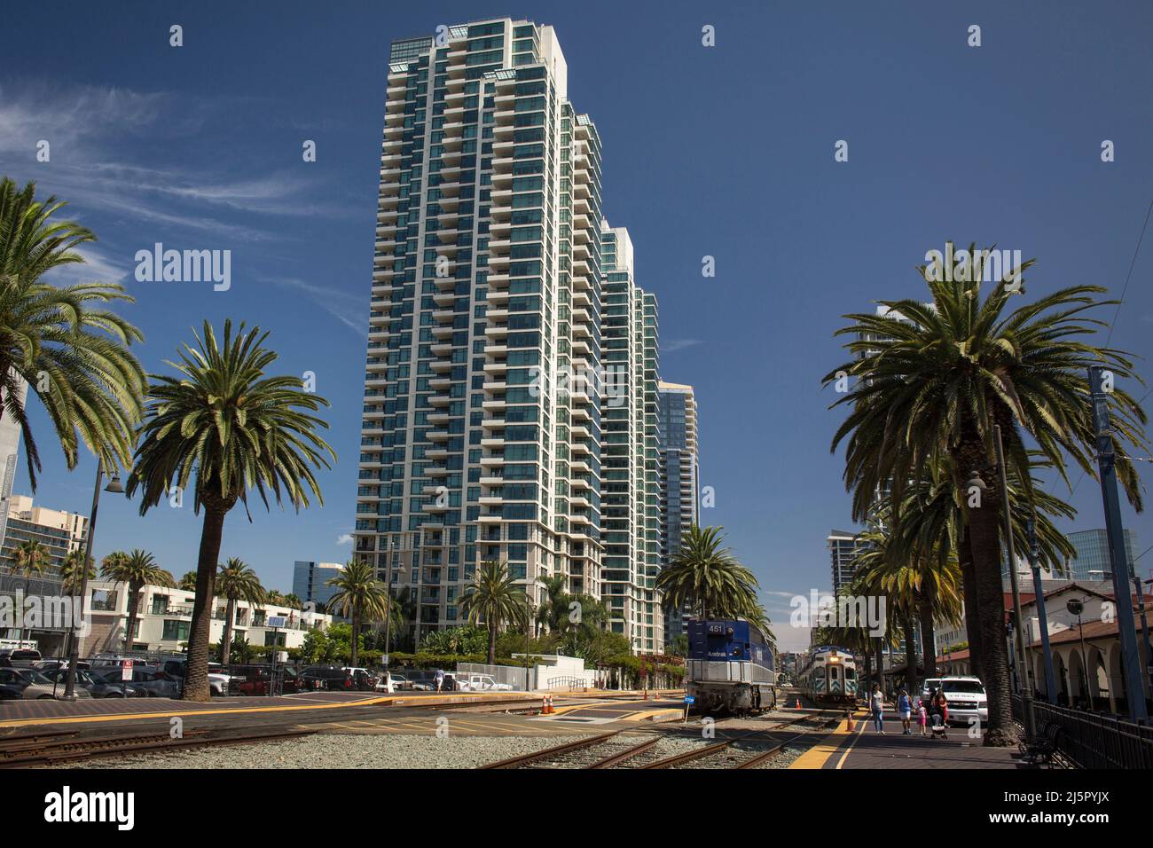 Züge und Gleise außerhalb des Santa Fe Depot, umgeben von Palmen und Wolkenkratzern in der Innenstadt von San Diego Stockfoto