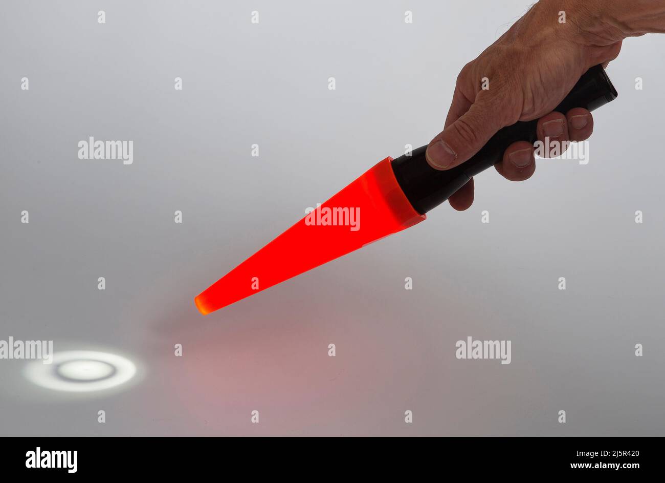 Eine Maglite-Taschenlampe mit rotem Kegel, die meist im Dunkeln von einem Verkehrskontrolleur verwendet wird. Stockfoto