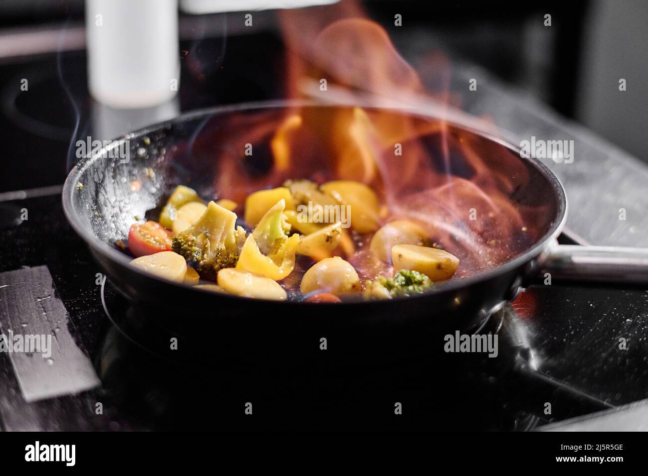 Nahaufnahme der Pfanne auf dem Herd mit Gemüse Kochen auf offenem Feuer im Restaurant Stockfoto