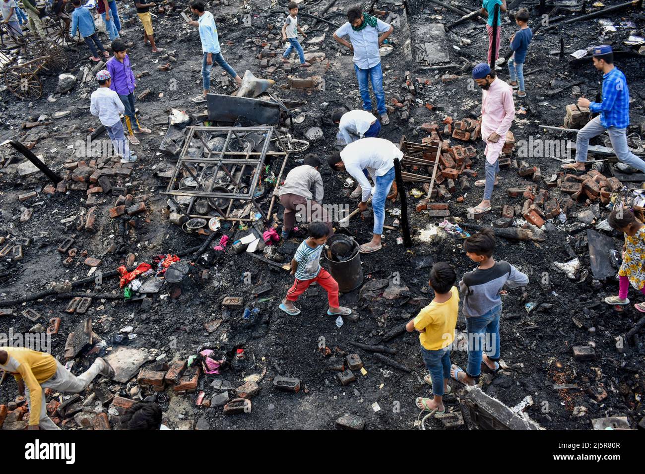 Neu-Delhi, Indien. 25. April 2022. Menschen, die ihre Reste sammelten, nachdem gegen 04:00 Uhr ein massives Feuer im Gebiet Dhobi Ghat in Jamia Nagar in der Nähe des Batla-Hauses ausgebrochen war, wurden auch vier Haustiere und Rikschas beim Feuer verbrannt, keine Verletzung wurde am 25. April 2022 in Neu-Delhi, Indien, gemeldet. Die Feuerwehrmänner wurden eilig an die Stelle gebracht, um das Feuer zu entfachen. (Foto von Mohsin Javed/Pacific Press) Quelle: Pacific Press Media Production Corp./Alamy Live News Stockfoto