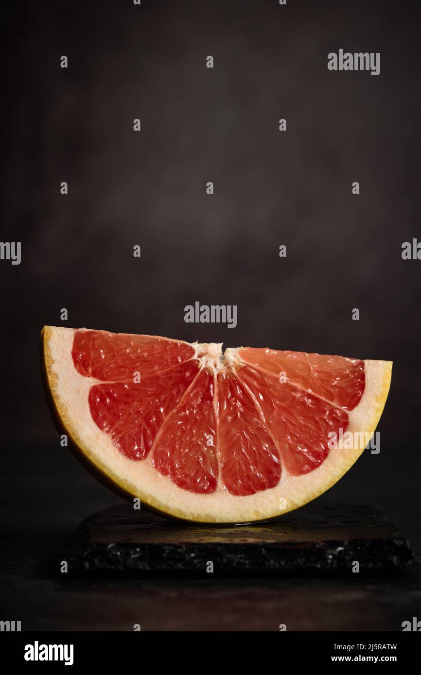 Ein Stück Grapefruit auf dunklem Hintergrund Stockfoto