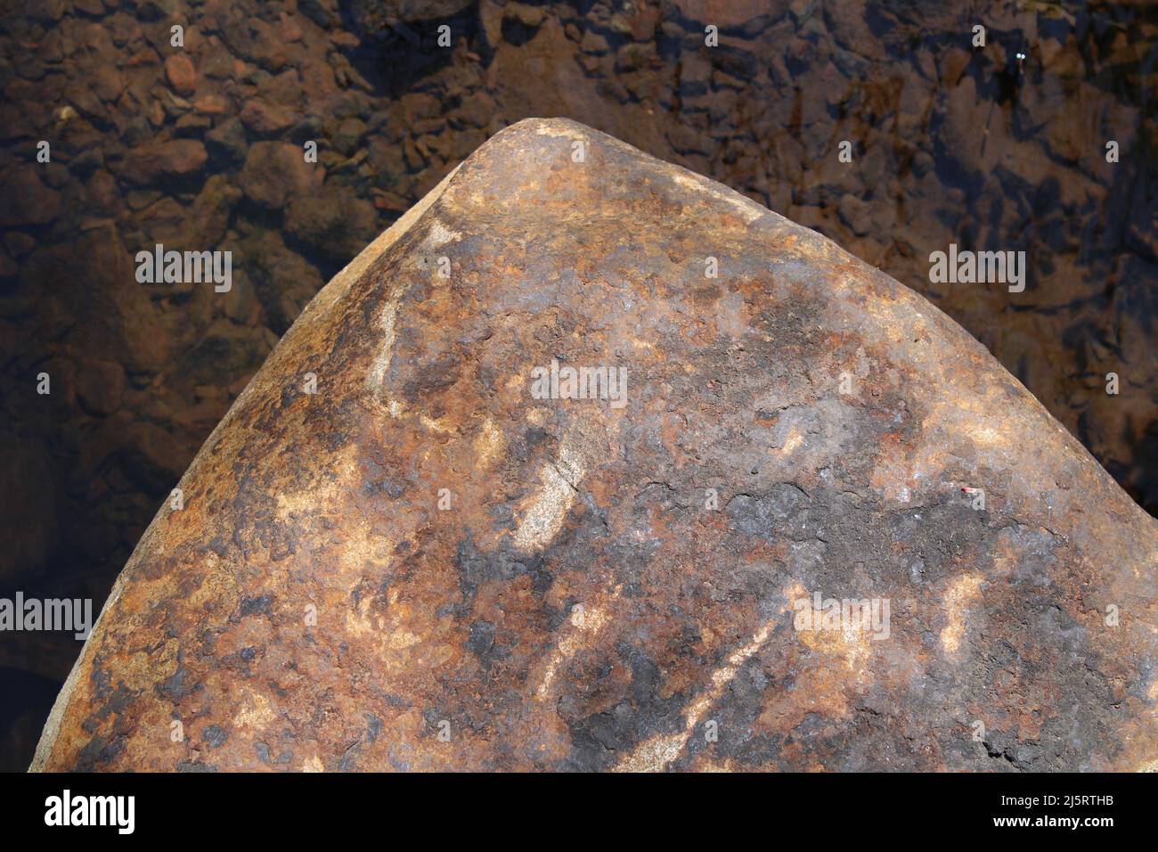 Der spitze Rand eines braunen und orangen Felsens Stockfoto