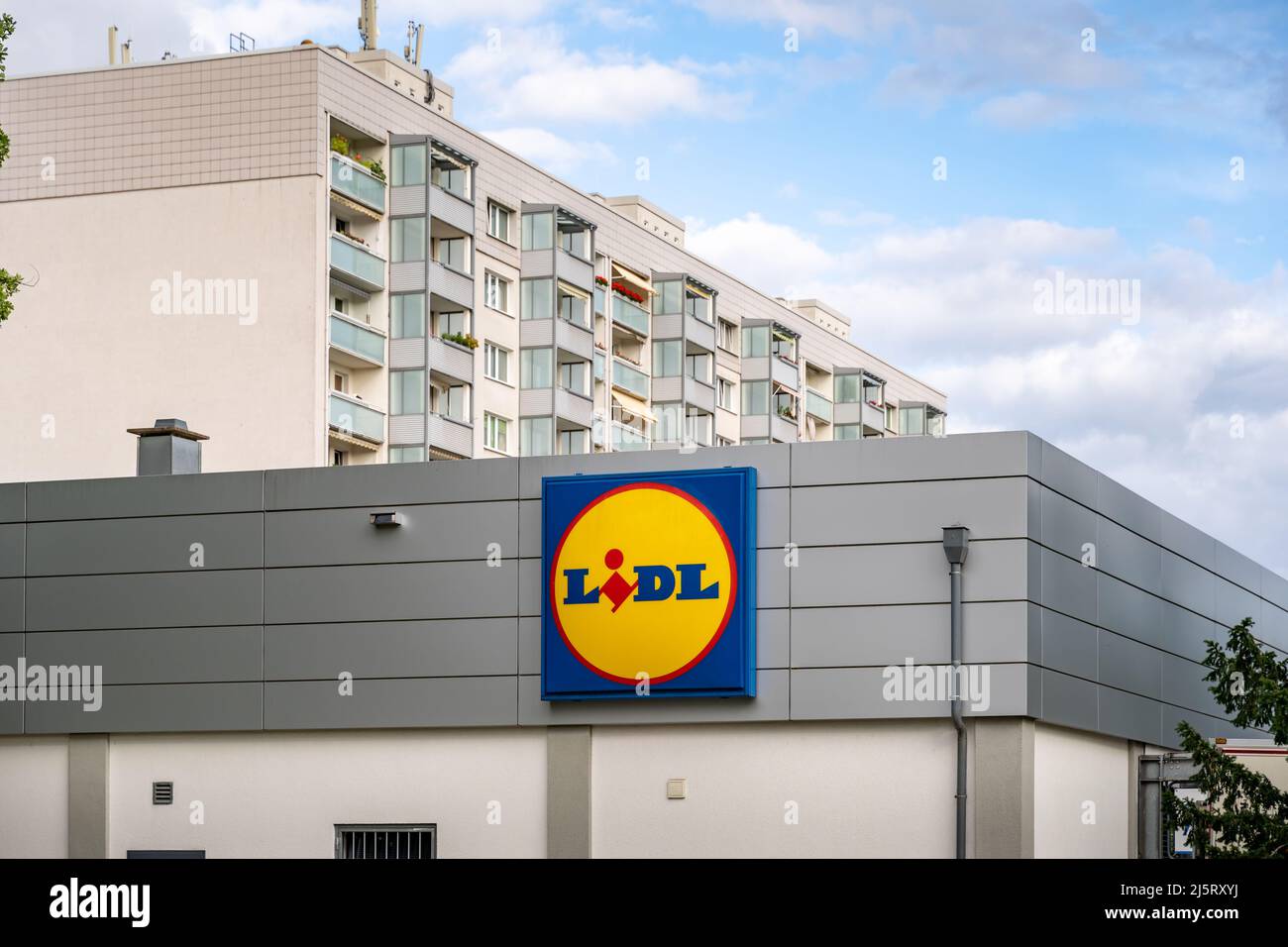 Lidl-Supermarkt vor einem Wohnhaus in der Stadt. Berühmter Supermarkt mit einem großen Logo an der Fassade. Lebensmitteldiscounter in Europa. Stockfoto