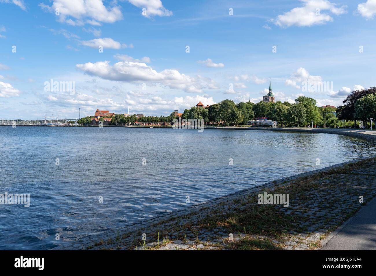 Stadtbild von Stralsund mit der Ostsee im Vordergrund. Eine schöne hansestadt an einem sonnigen Sommertag. Der blaue Himmel ist mit Wolken bedeckt. Stockfoto