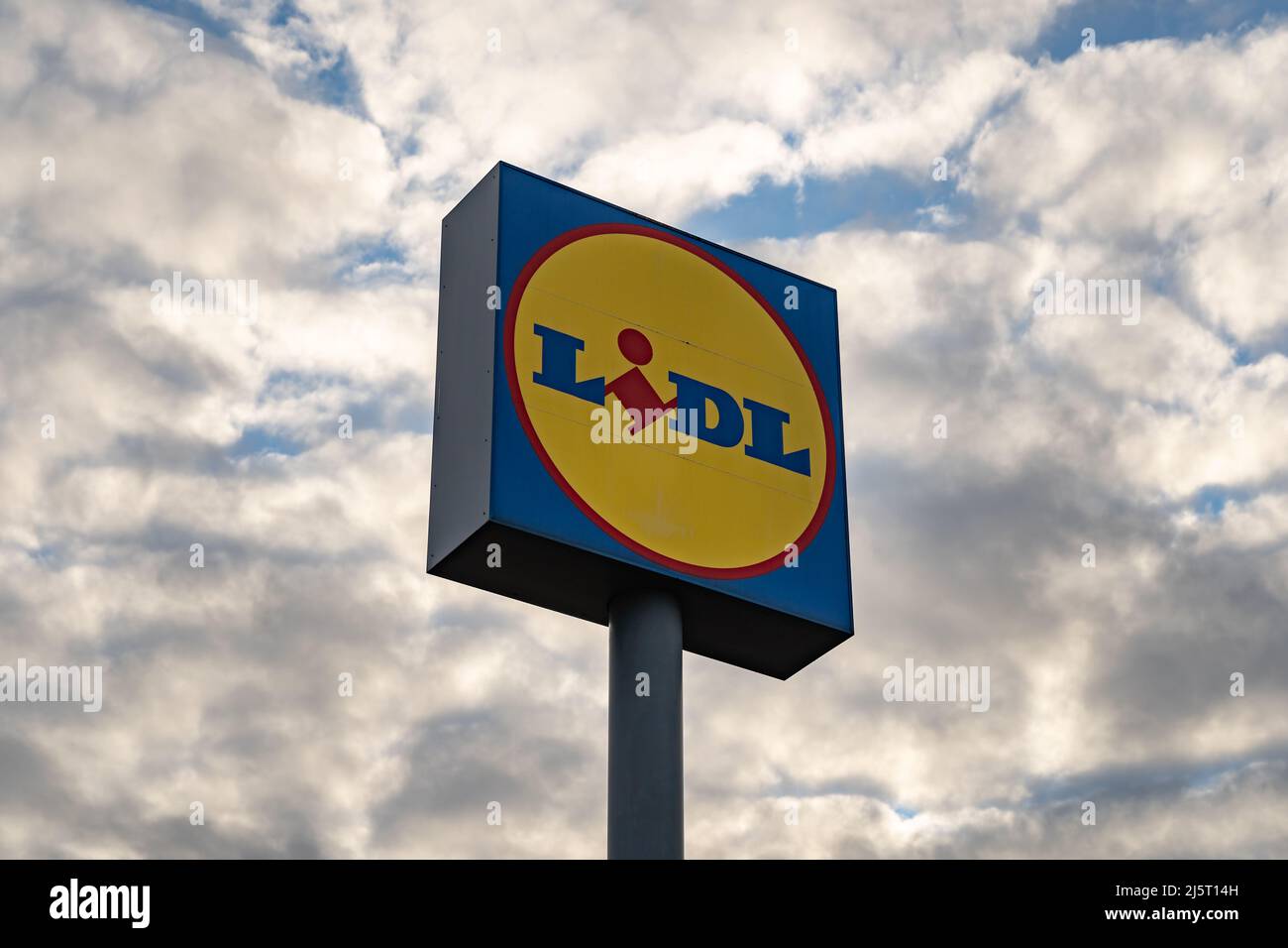 LIDL-Schild vor einem wolkigen Himmel. Großes riesiges Schild, das von weitem sichtbar ist, um zum Supermarkt zu gelangen. Werbung für den Lebensmitteldiscounter. Stockfoto