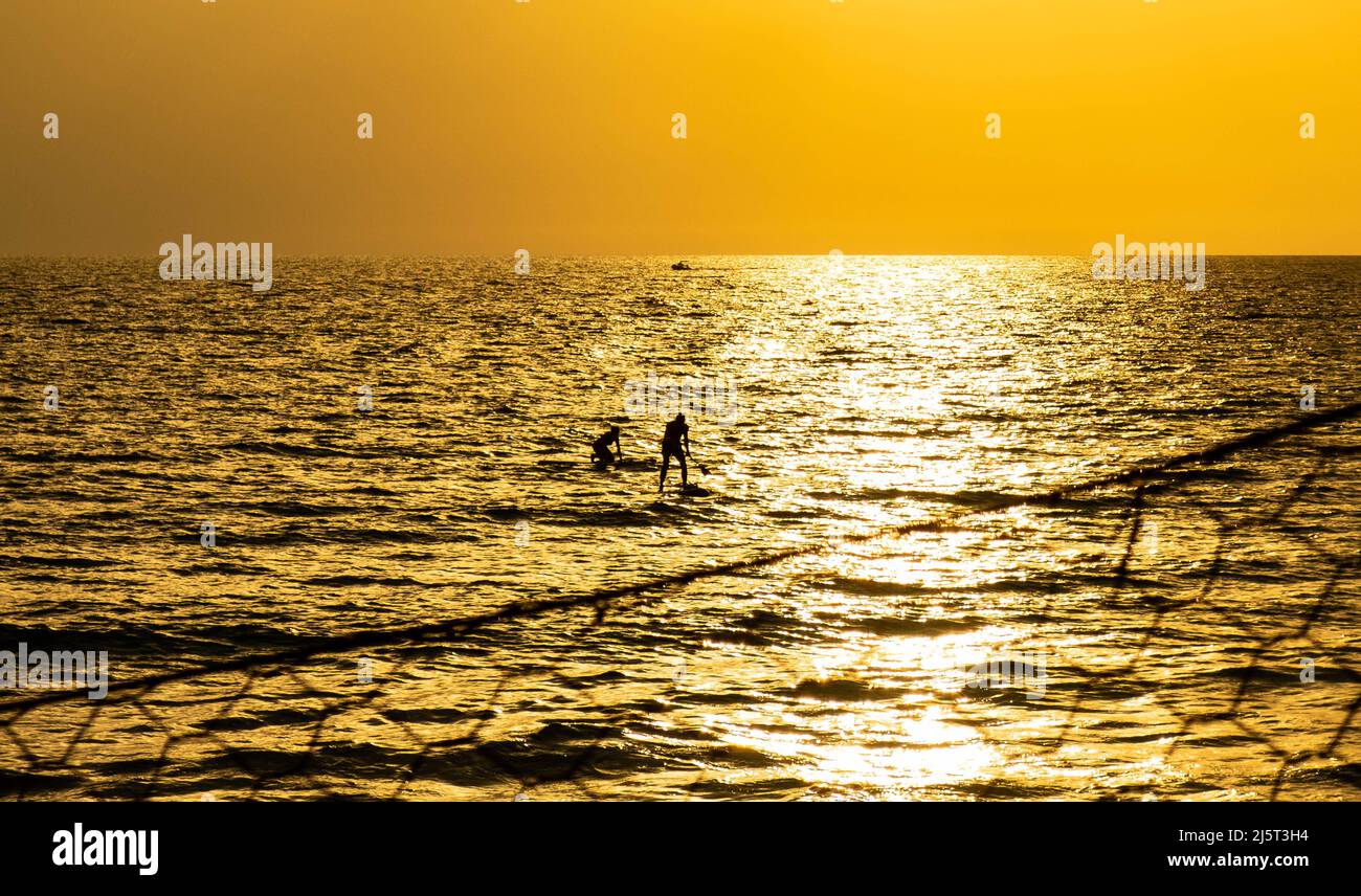 Paar reiten Stand Up Paddle am Strand von Gaeta, Lazio (Italien), bei Sonnenuntergang Stockfoto