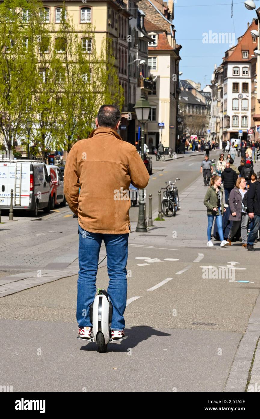 Straßburg, Frankreich - 2022. April: Person, die auf einem elektrischen selbstbalancierenden Einrad auf einer Straße im Stadtzentrum von Straßburg fährt Stockfoto