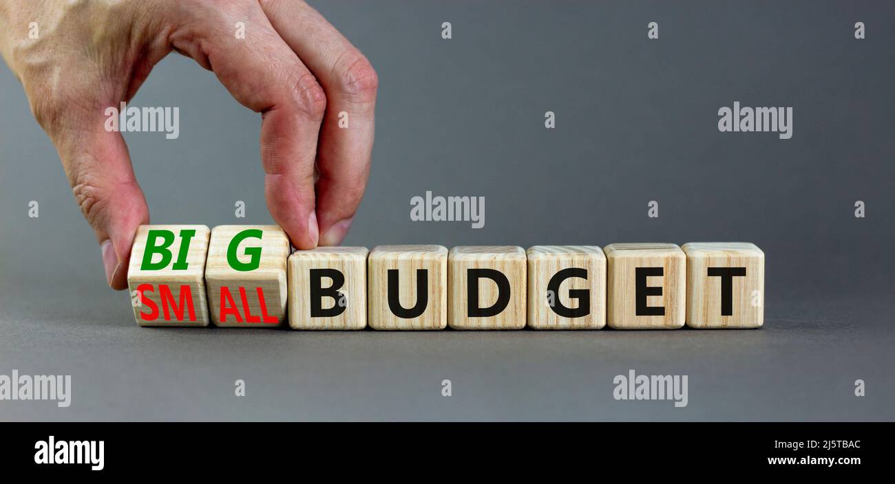 Großes oder kleines Budgetsymbol. Geschäftsmann dreht Holzwürfel und ändert Wörter kleines Budget zu großes Budget. Schöne graue Tabelle grauen Hintergrund, Kopie sp Stockfoto