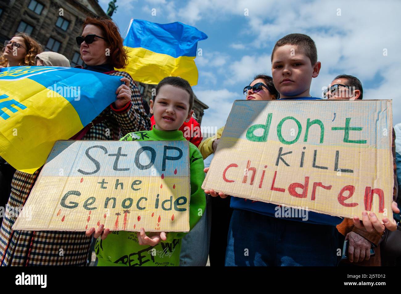 Während der Demonstration werden zwei ukrainische Kinder mit Plakaten gegen den Krieg in der Ukraine gesehen. Die ukrainische Gemeinschaft in den Niederlanden, hauptsächlich Frauen und Kinder, versammelte sich im Zentrum der Stadt, um die Aufmerksamkeit der Welt auf die schrecklichen Tragödien der Kinder in der Ukraine zu lenken, die durch die russische Aggression verursacht wurden. Innerhalb von 21 Tagen nach dem Krieg in der Ukraine (Stand: März 16) wurden mindestens 108 Kinder beim Beschuss der russischen Streitkräfte getötet und mehr als 100 verletzt. Während des Protestes hielten einige der Frauen Puppen in einer weißen Decke mit gefälschten Blutflecken. (Pho Stockfoto