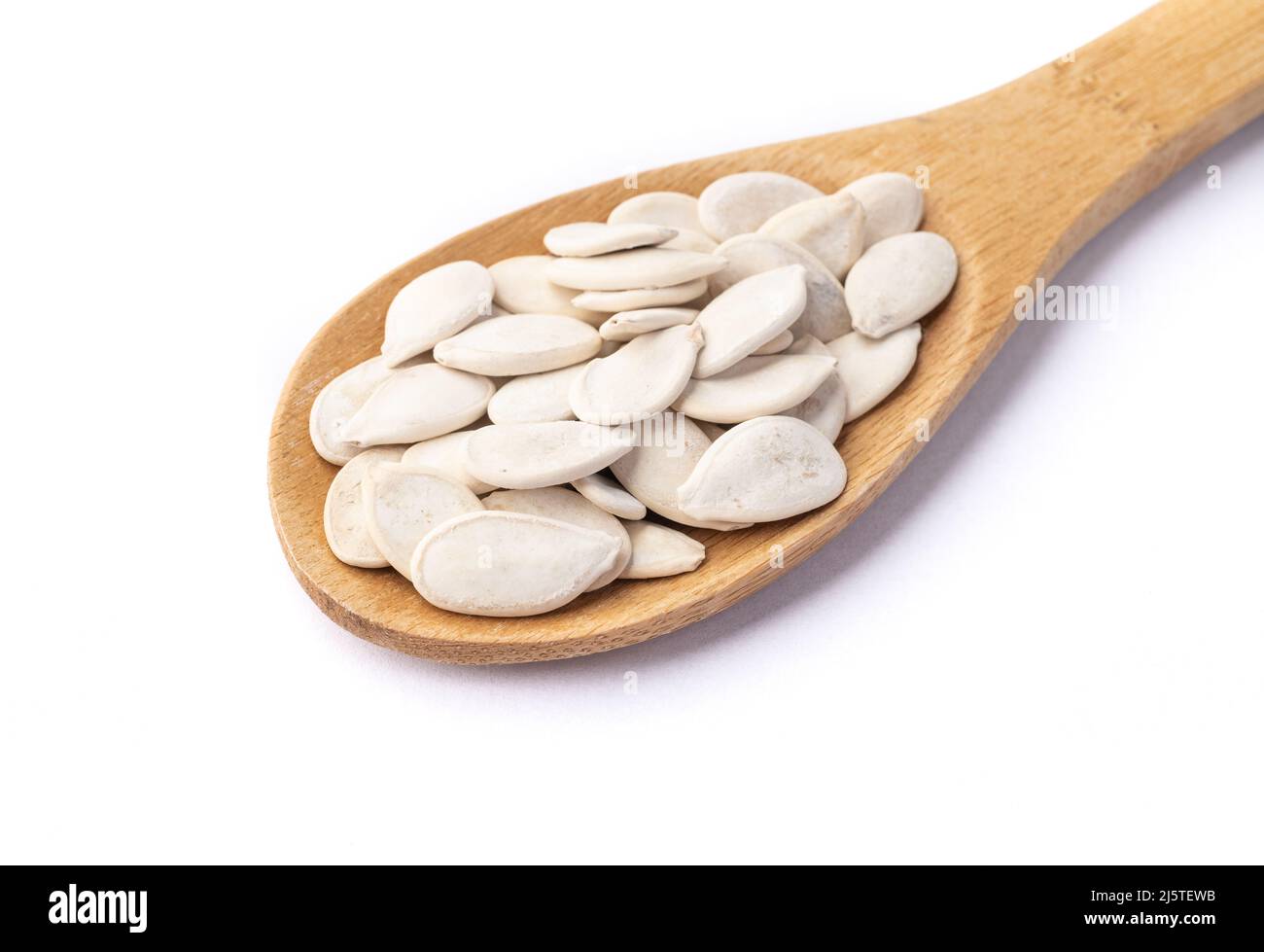 Geschälte Kürbiskerne in einem Löffel isoliert auf weißem Hintergrund. Stockfoto