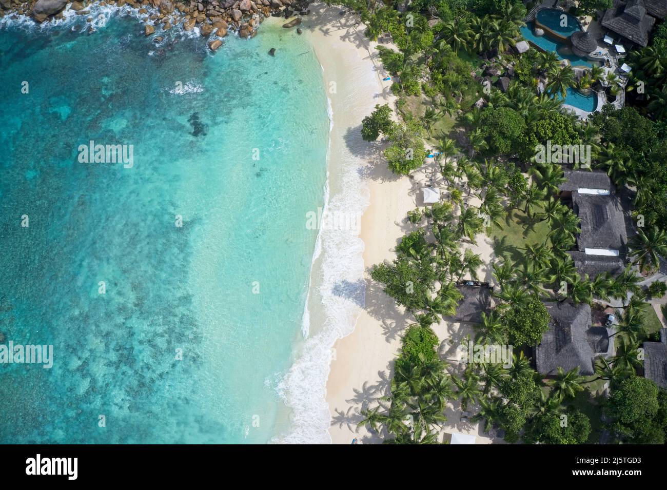 Drohne Sichtfeld der Küste und Häuser mit spektakulärer blauer Bucht auf Praslin, Seychellen. Stockfoto