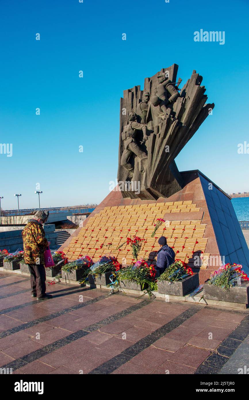 Dnipro, Ukraine - 15.02.2022: Denkmal für Veteranen des Afghanistankrieges 1979-1989. Rote Nelken auf der Granitplatte des Denkmals. Die Menschen ehren den m Stockfoto