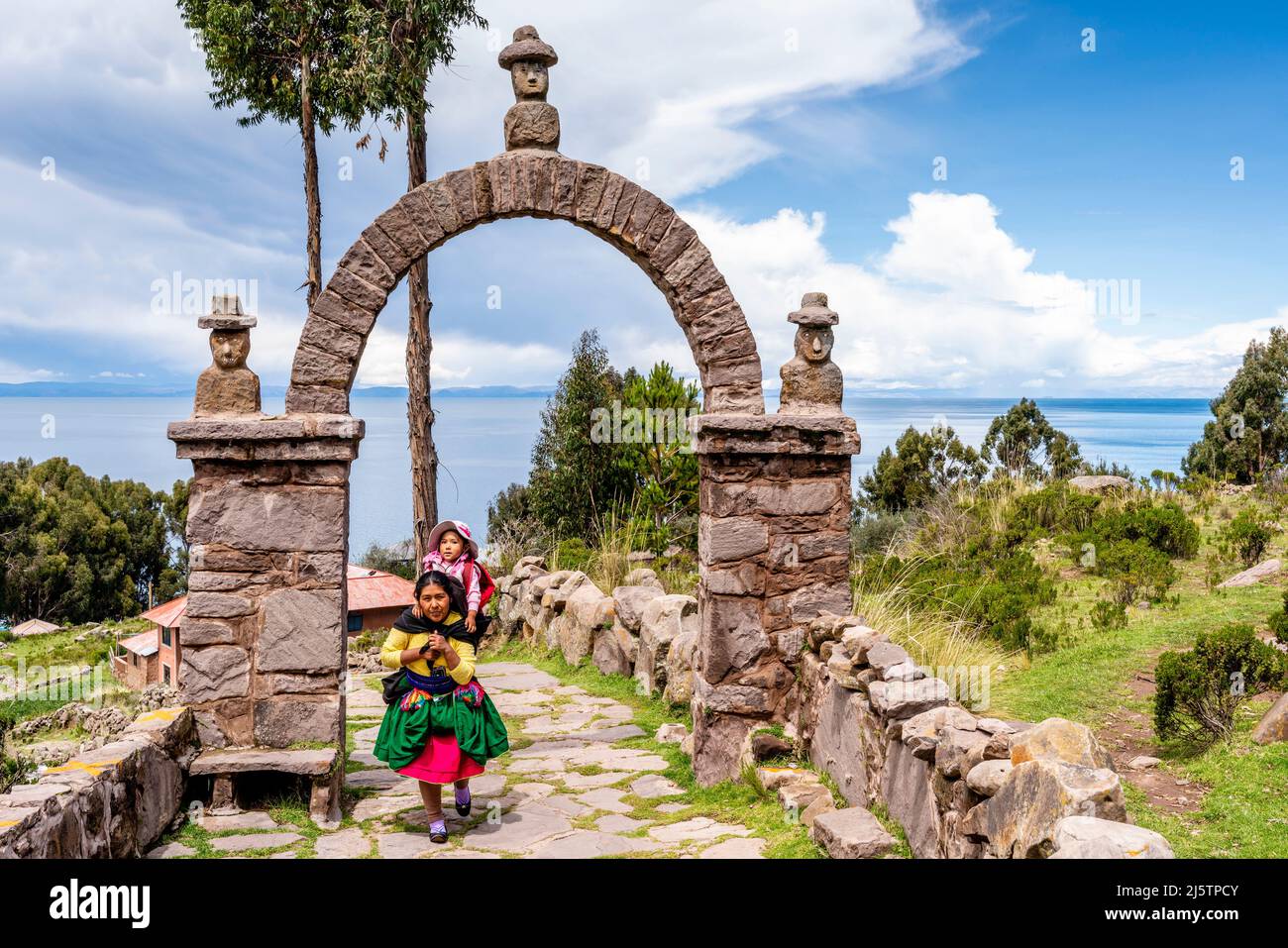 Eine Mutter und ein Kind von Taquileno, die den Weg vom Hafen zur Stadt, zur Insel Taquile, zum Titicacasee, Puno, Peru, hinaufgehen. Stockfoto
